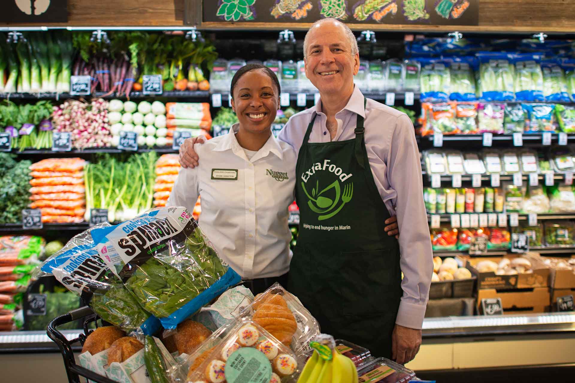 Nugget Markets’ store director poses with Extra Food program representative