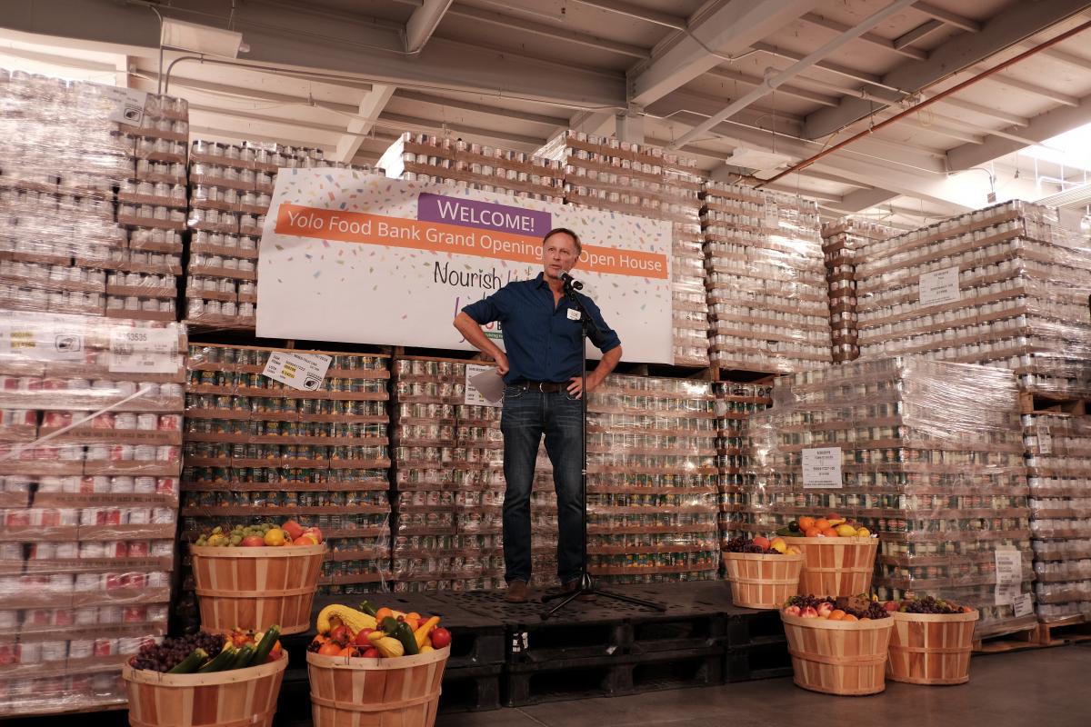man on stage at yolo food bank warehouse